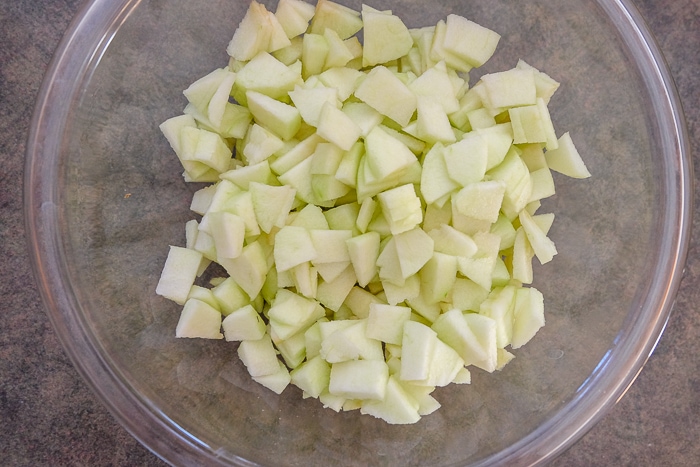pieces of green apple in clear glass mixing bowl on counter