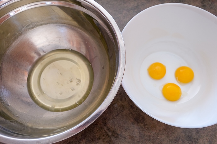 separated eggs into yolks and whites in bowls on counter