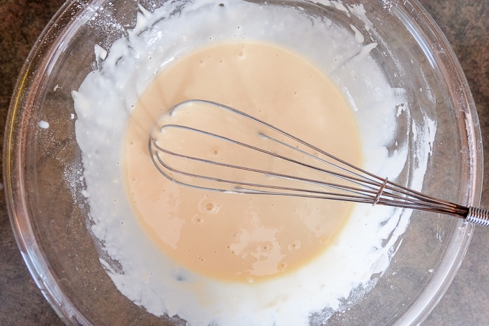 wet german pancake batter in bowl with whisk