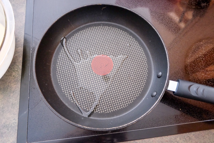 frying pan with hot oil inside on stove top