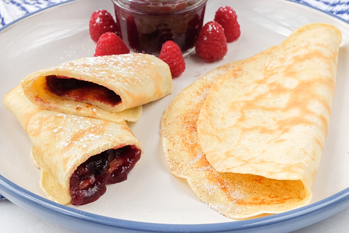 german pancakes on large plate with sugar and jam inside