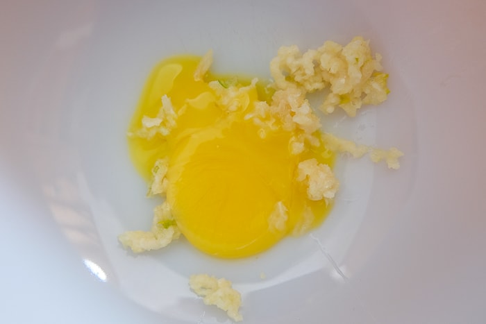 egg yolk and garlic in white mixing bowl