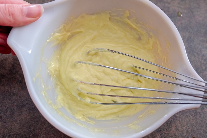 thickening aioli with whisk in mixing bowl