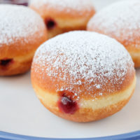 krapfen jelly filled donuts on blue and white plate with powdered sugar on top