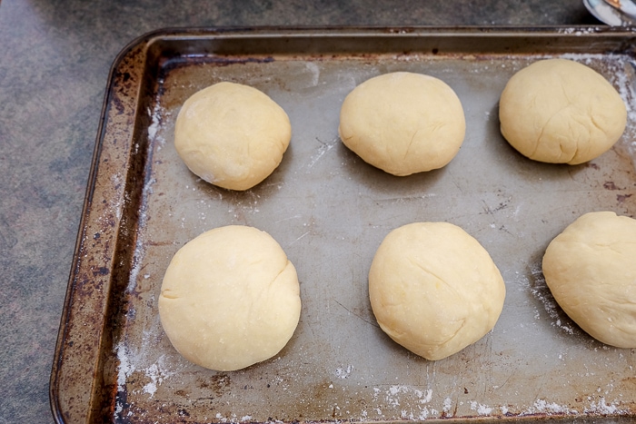 balls of krapfen dough on metal baking sheet