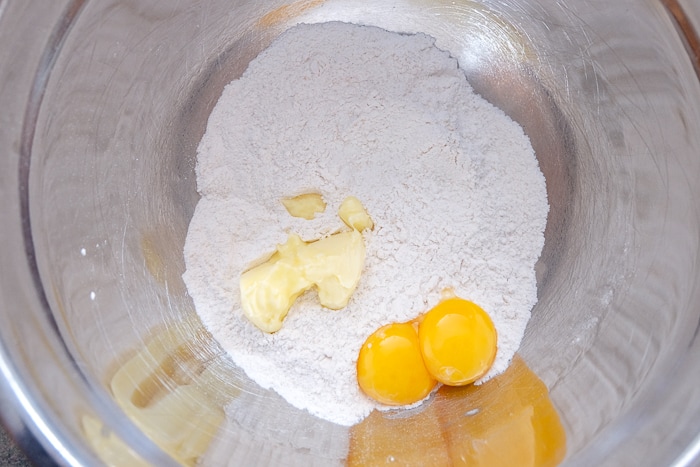 egg yolks and butter with flour in silver mixing bowl