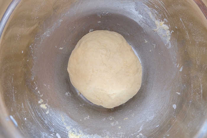 ball of yeast dough in silver mixing bowl