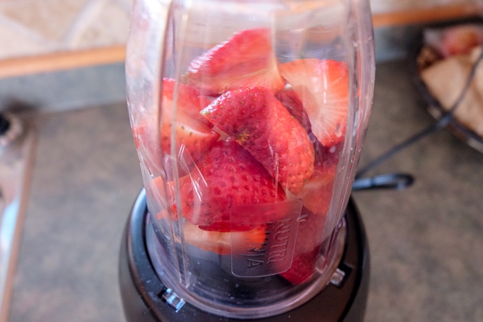 strawberries in small blender on counter top