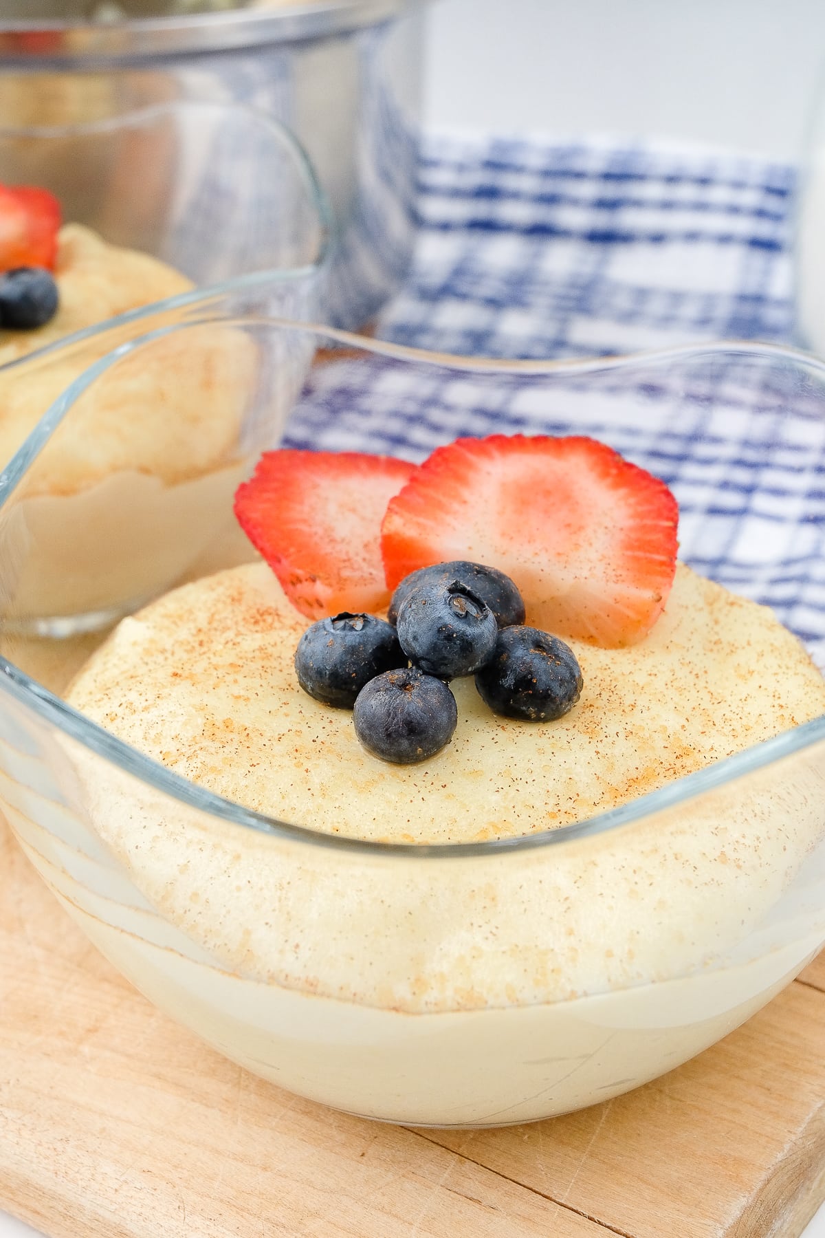 semolina pudding in clear glass bowl on wood with berries on top
