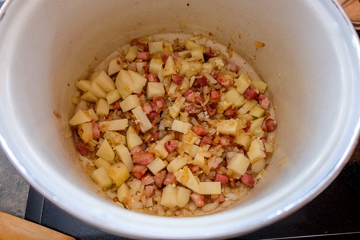 potatoes onions and pancetta in pot on stove