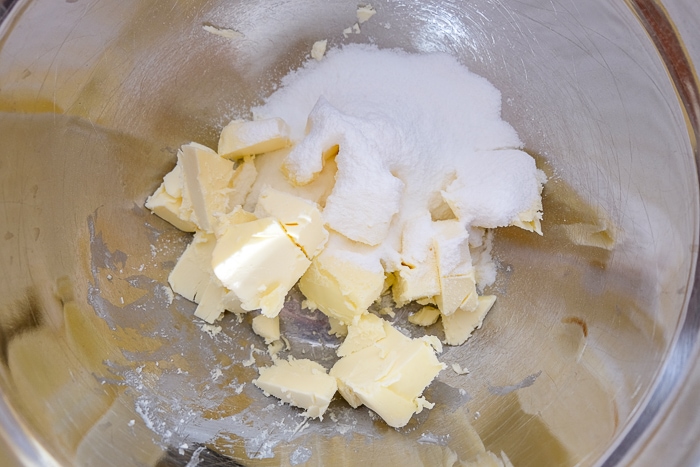 butter and sugar in silver mixing bowl on counter