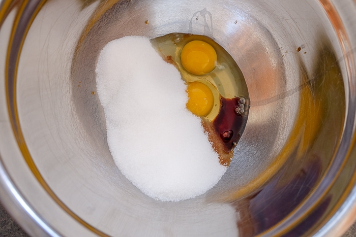 sugar eggs and other ingredients in silver mixing bowl on counter