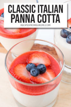 three glasses with white panna cotta and strawberry puree, strawberry slices and blueberries on top plus text overlay saying "Classic Italian Panna Cotta"