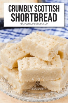 shortbread fingers with fork holes stacked on clear plate with text overlay saying "crumbly scottish shortbread"