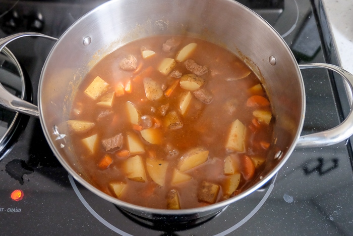 hungarian goulash simmering in large silver pot on stove