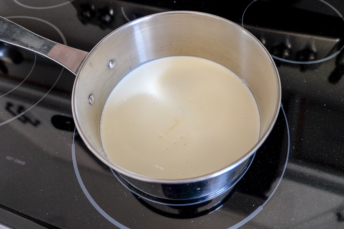 silver pot with milk and cream boiling on stove top