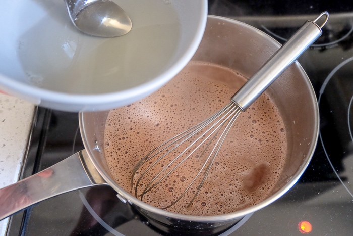mixing gelatin into melted chocolate ingredients in pot on stove top
