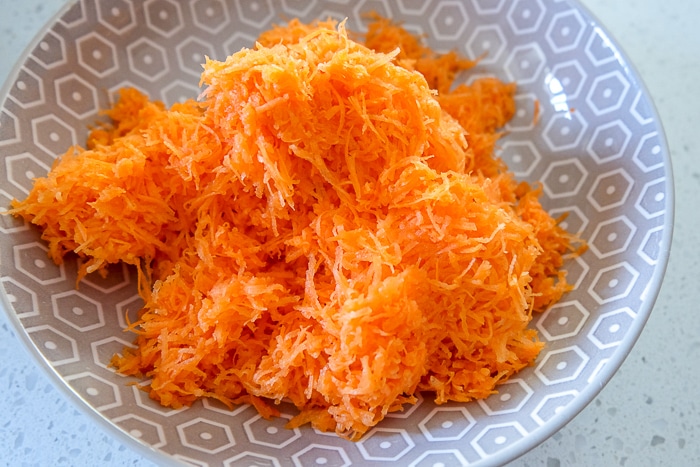 grated carrot in bowl on white counter