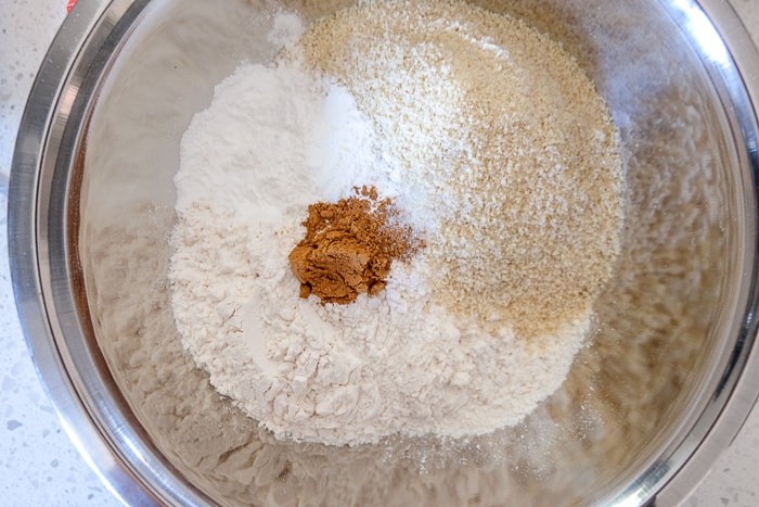 flour and dry ingredients in silver mixing bowl on counter