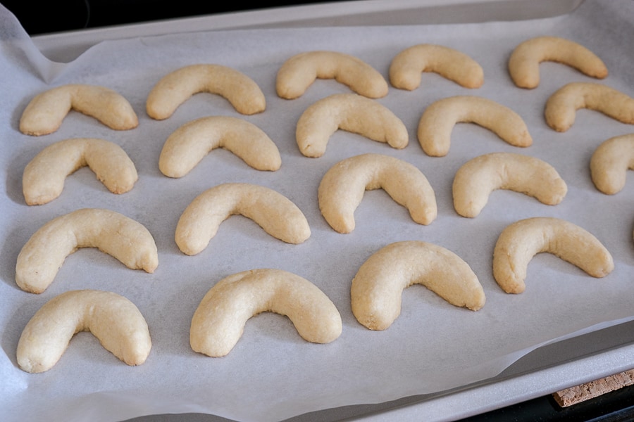 baked crescent cookies in parchment paper on cookie sheet