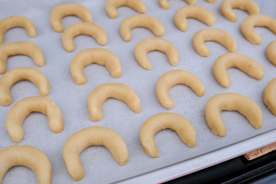 raw crescent cookies on parchment paper on cookie sheet