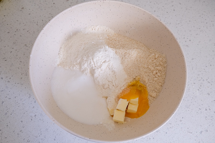 cookie ingredients in white mixing bowl on white counter top