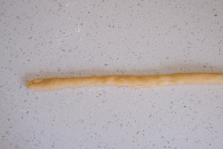 long sausage of cookie dough on white counter