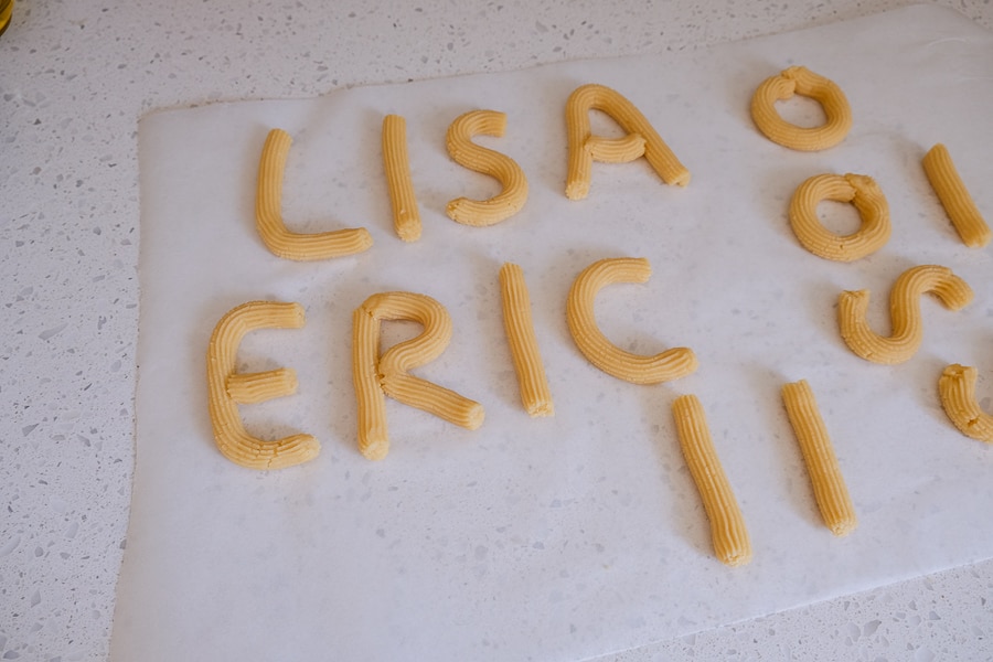 letters written in raw spritz cookie dough in parchment paper
