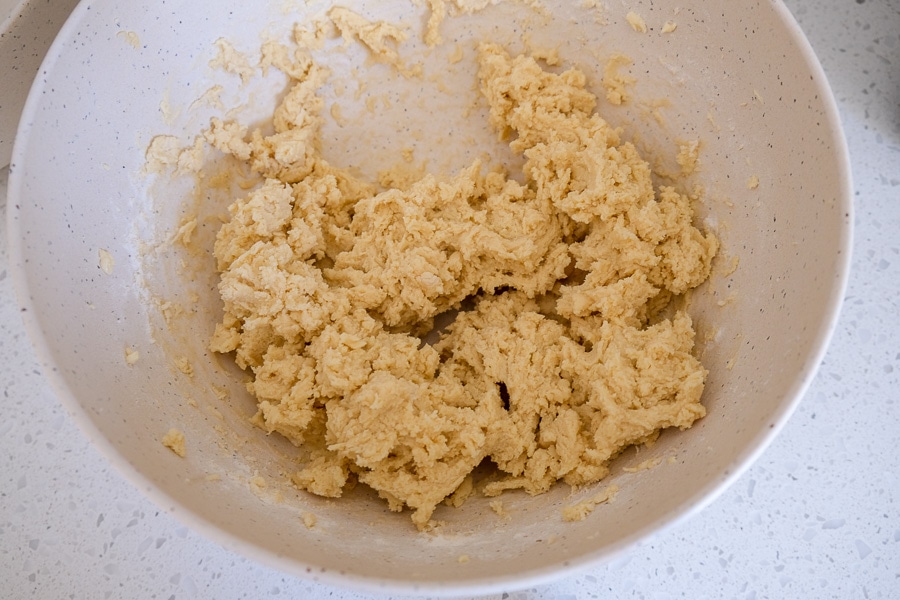mixed spritz cookie dough in mixing bowl on counter top