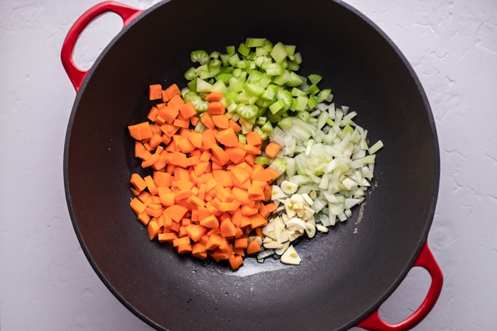 chopped vegetables in black pot on white counter.