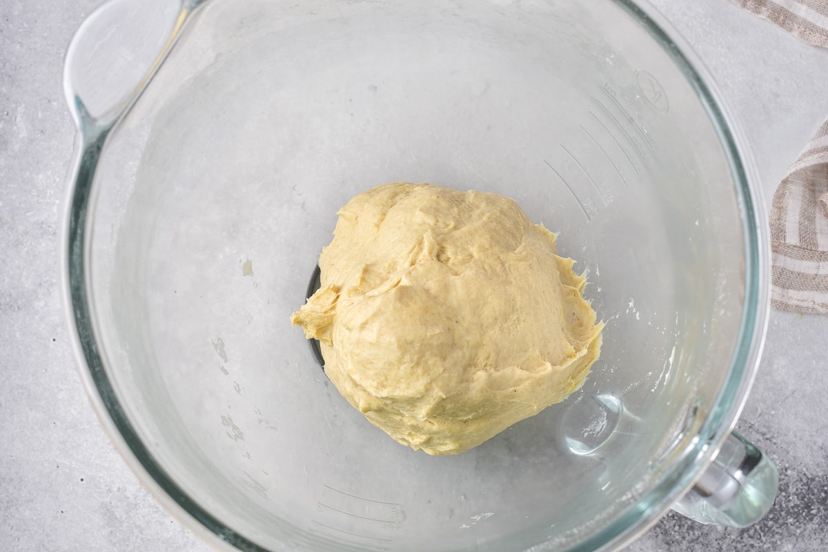 ball of dumpling dough sitting in glass bowl in counter top.