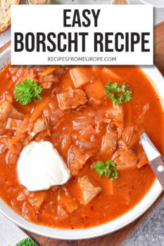 red borscht in white bowl with sour cream and parsley and text overlay "easy borscht recipe".