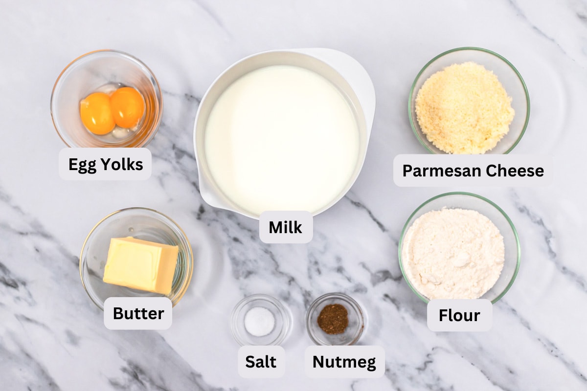 ingredients for creamy bechamel sauce on counter in bowls with labels.
