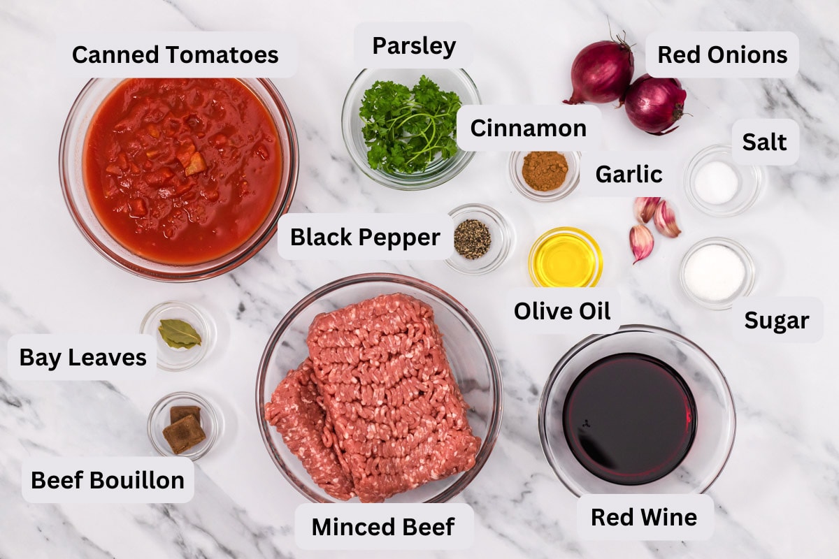 ingredients needed for meat sauce on counter in bowls on labels.