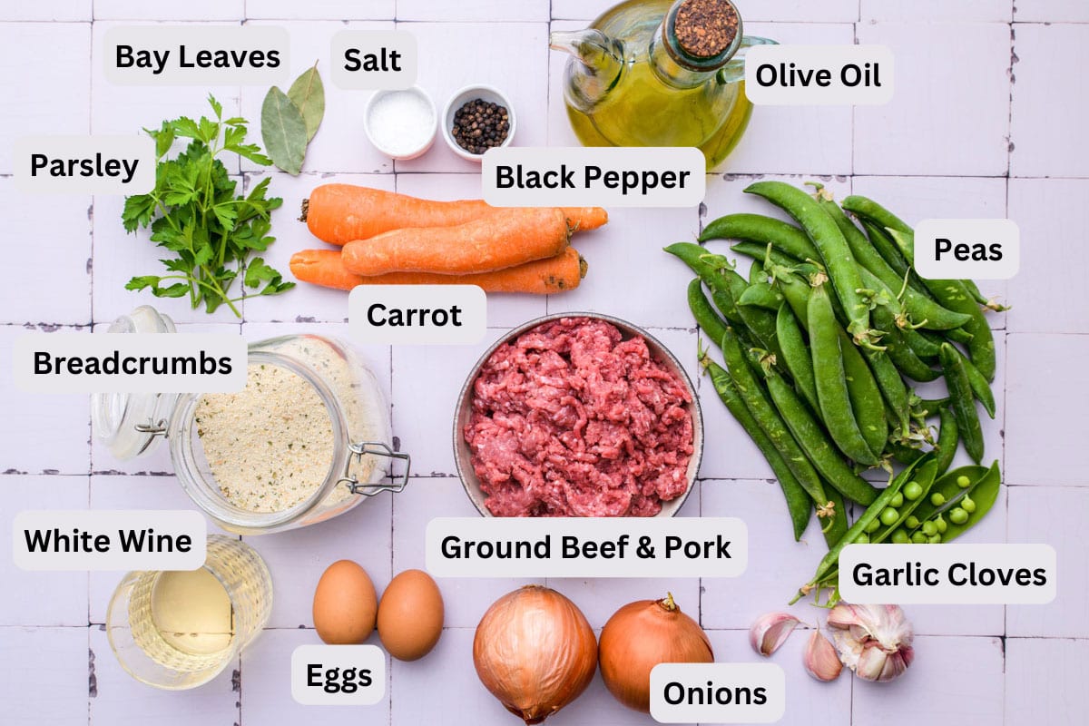 ingredients to make meatballs like ground meat and vegetables on counter with labels.