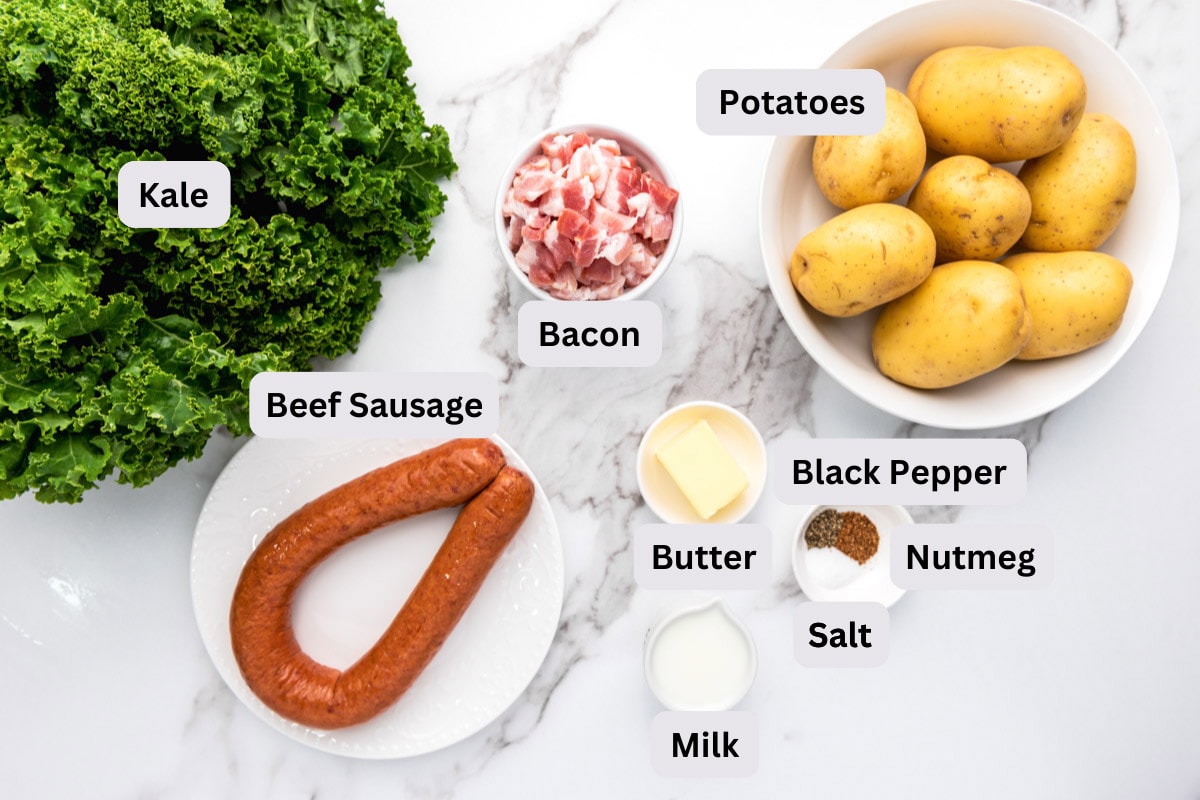ingredients like potatoes and smoked sausage and kale in bowls with labels in white counter top.