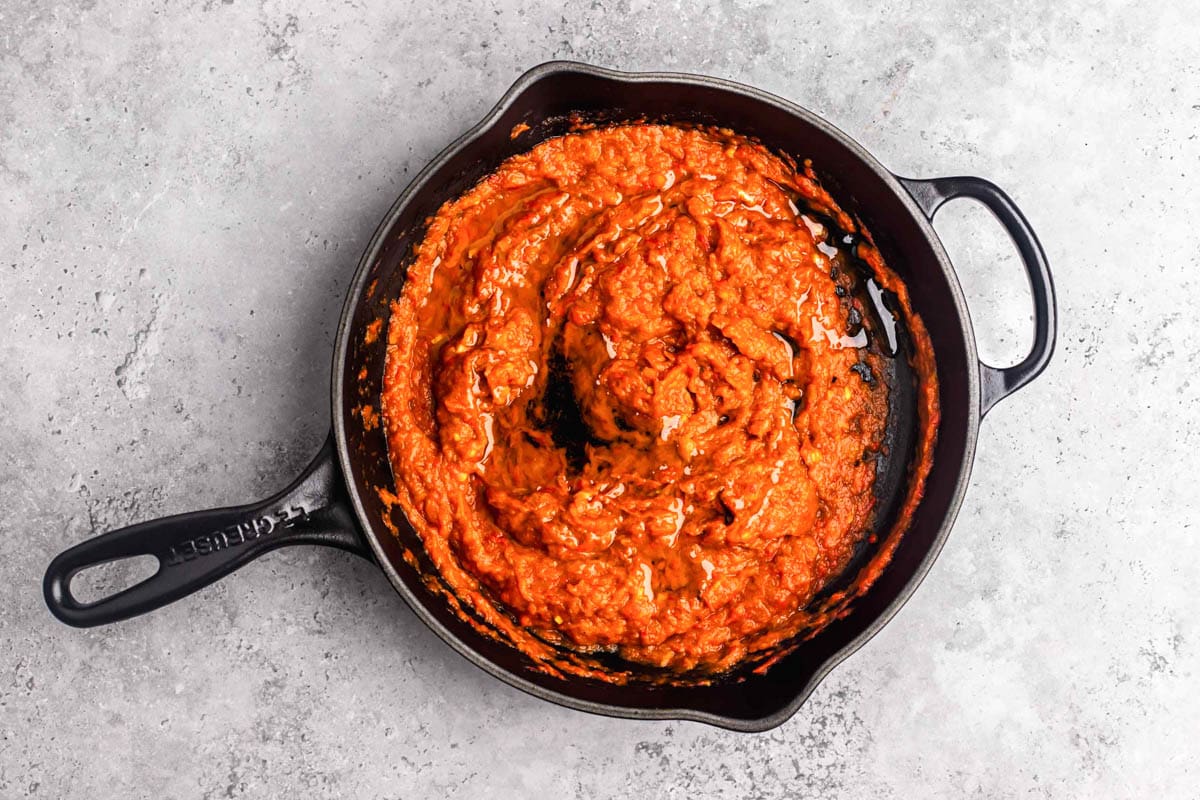 red pepper spread cooking in cast iron pan.