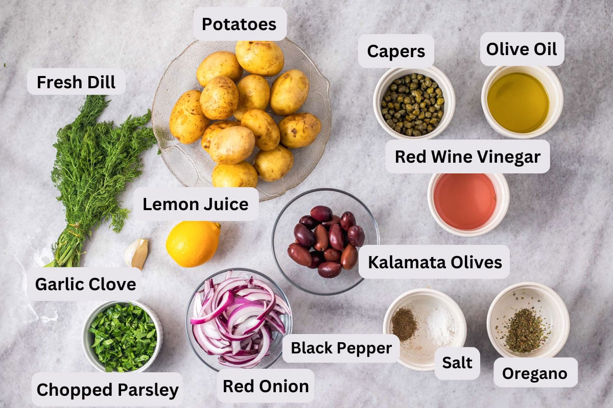 many ingredients to make potato salad on grey counter with labels on them.