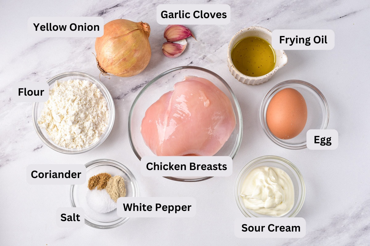 ingredients to make chicken patties in glass bowls on counter with labels.