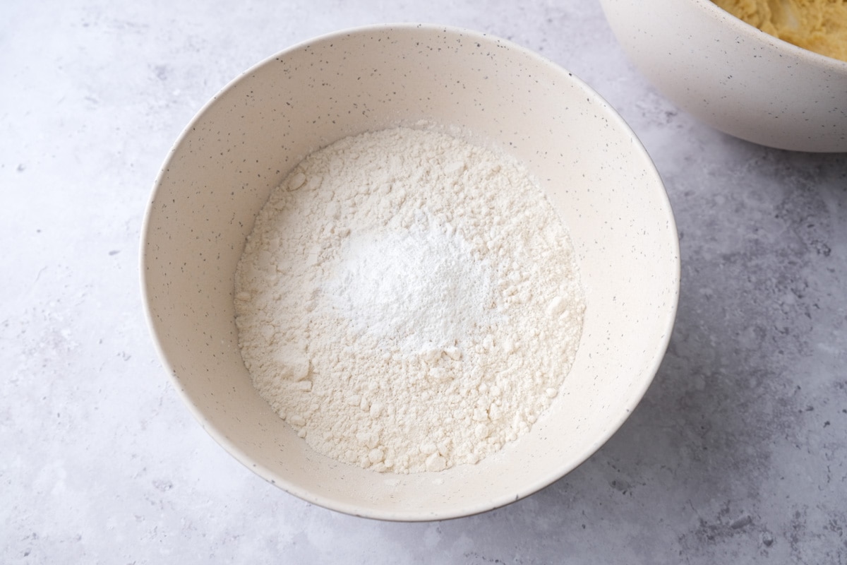 dry ingredients like flour in large mixing bowl on grey counter.