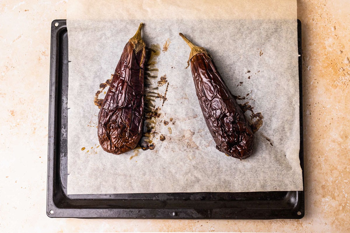 oven roasted eggplant on parchment paper on baking tray on counter.
