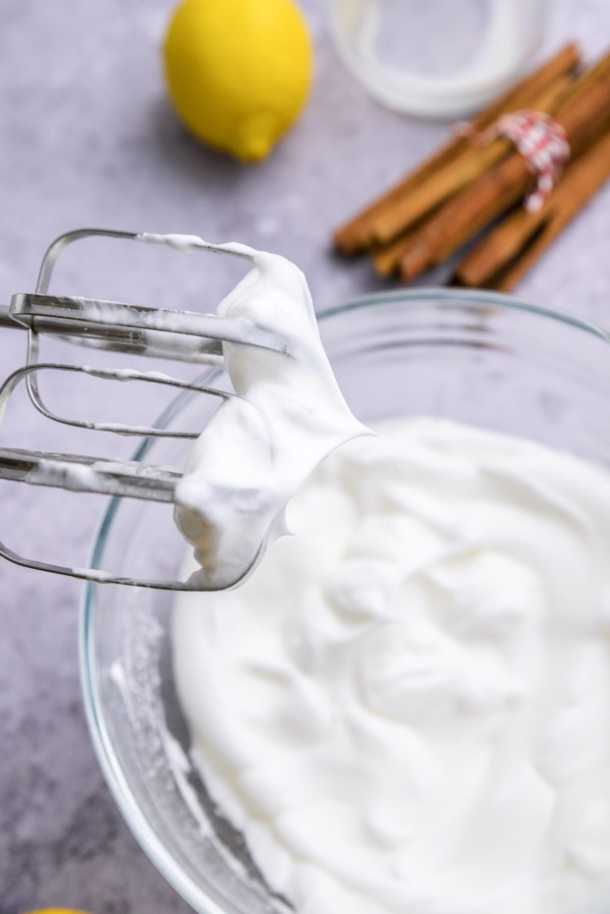 two electric mixer beaters tipped with white meringue.