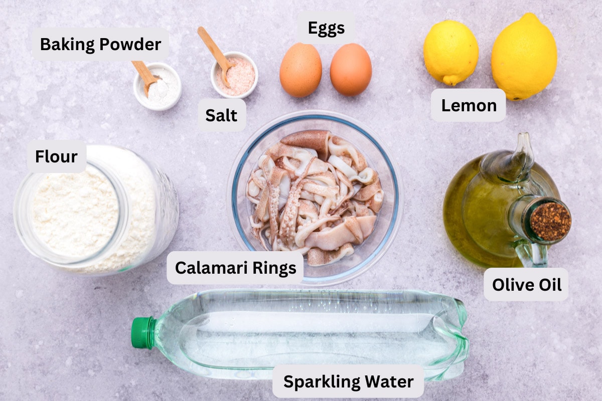 ingredients to make fried calamari on counter on bowls with labels.