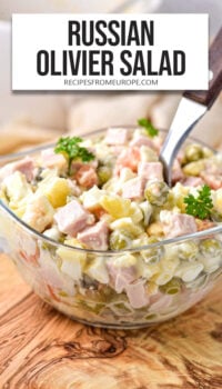 creamy potato salad in small clear bowl with text overlay "Russian Olivier Salad".
