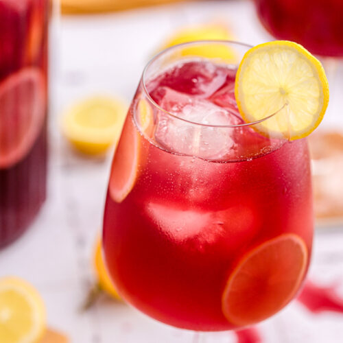 red wine drink with lots of ice and lemon slice in wine glass.