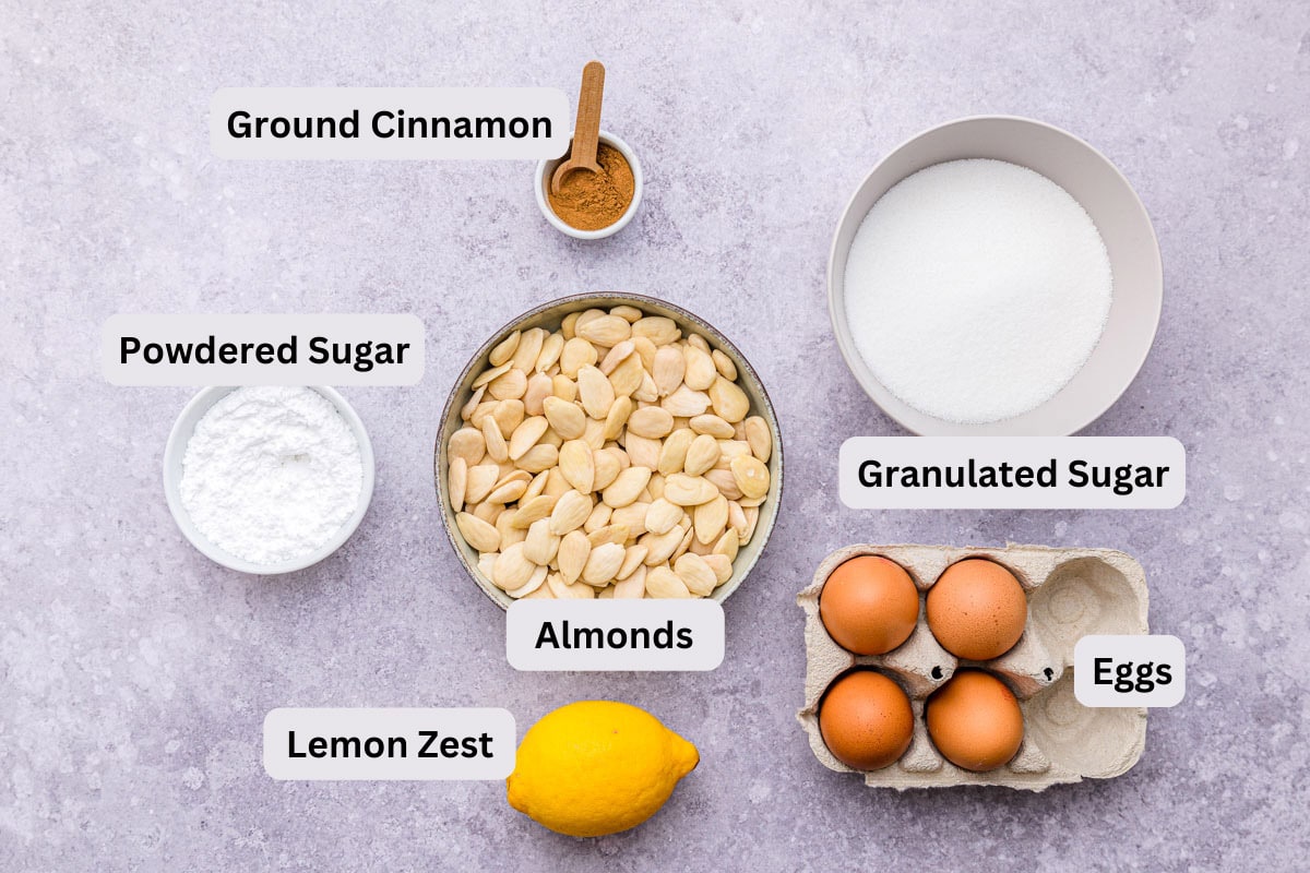 ingredients on counter in bowls with labels for spanish almond cake.