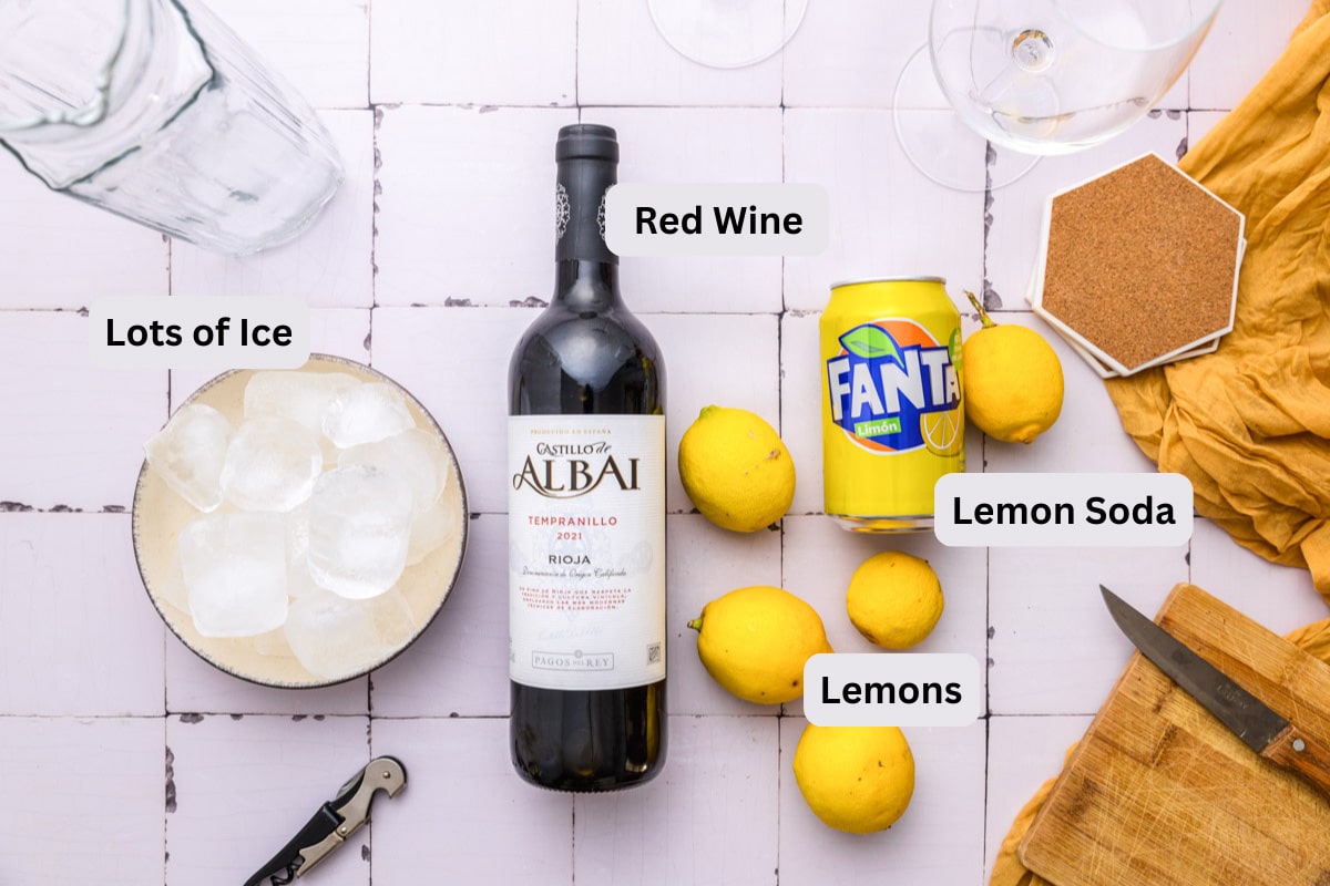 ingredients to make spanish red wine drink on tile counter top with labels.