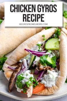 chicken with tzatziki, cucumbers and other ingredients in pita bread with text overlay "chicken gyros recipe".