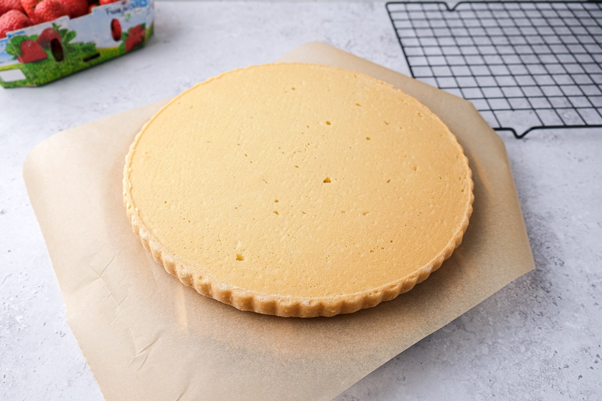 round bake flat cake flipped onto parchment paper on counter.