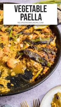 vegetable paella in black pan with plate next to it and text overlay "vegetable paella".